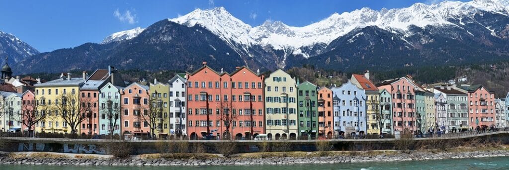 Blick auf die malerische Stadt Innsbruck in den Alpen mit einer Auswahl an Speichermedien, die Datenrettungsdienste symbolisieren.